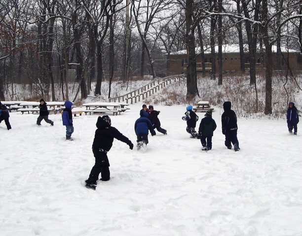 Kids playnig in the snow during nature camp.